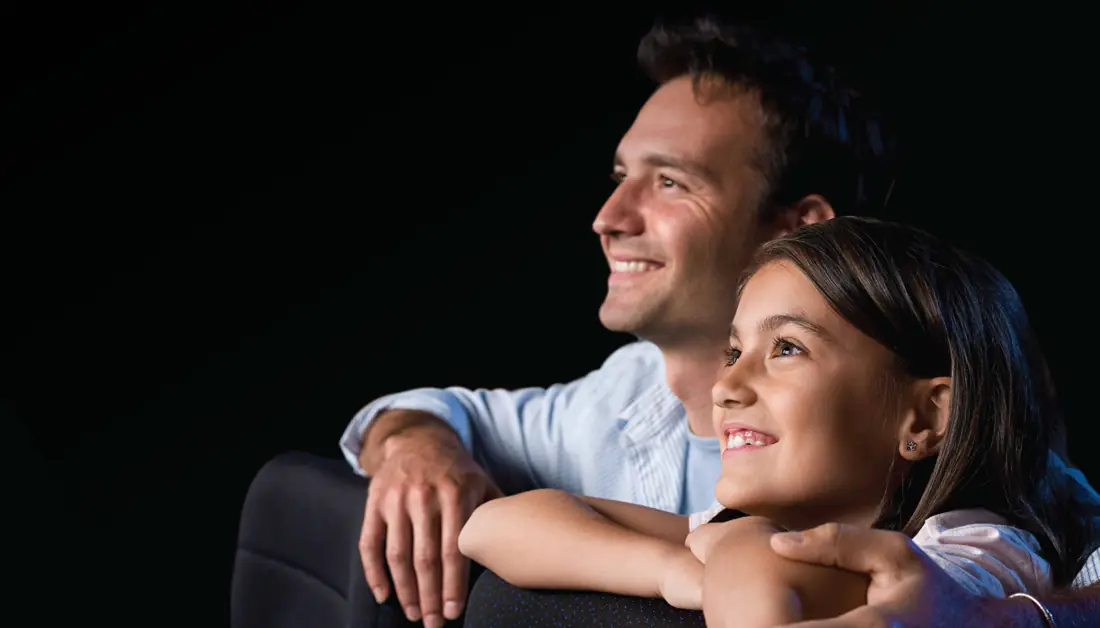 Father and daughter enjoying a film
