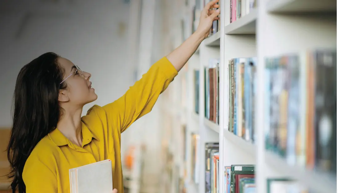 Woman choosing a book in a library